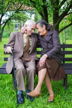 Cute 80 plus year old married couple posing for a portrait in their garden. Foto stock