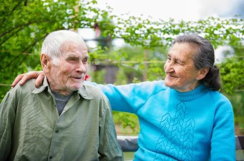 Cute 80 plus year old married couple posing for a portrait in their garden. Stock Photos
