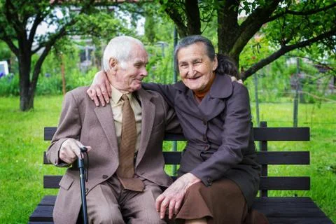 Cute 80 plus year old married couple posing for a portrait in their garden. Stock Photos