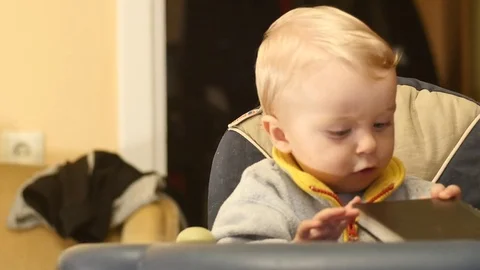 Cute 9-10 months old baby bites and tastes the book Stock Footage 82461753