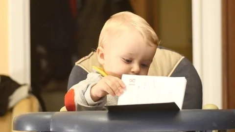 Cute 9-10 months old baby boy turn pages of book Stock Footage 82461765