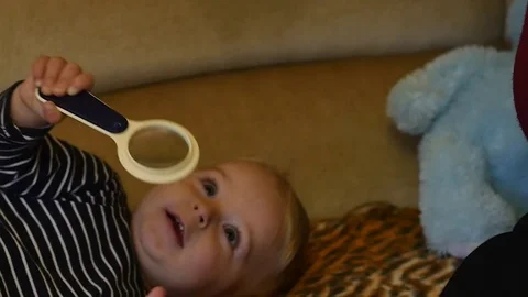 Cute 9-10 months old baby boy look into magnifying glass up Stock Footage 82571351