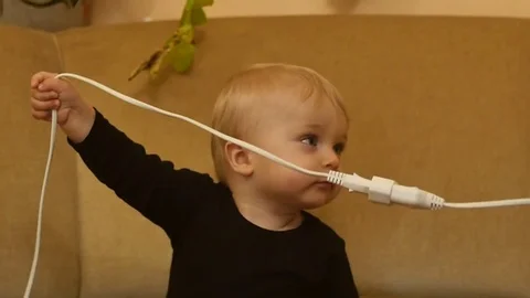 Cute 9-10 months old baby boy with electric wire slow motion Video stock 82780427