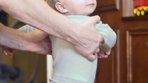 Cute 9 months old boy making first steps supported by father hands Stock Footage 82419932