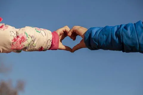 A cute abstract image showing the touching hands of a girl with pink coat and Stock-Fotos