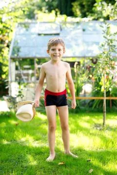 Cute active kid boy jumping in the garden on warm sunny summer day. Happy kid Stock Photos