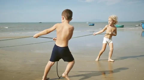 Cute adorable happy children pulling a rope on the tropical sandy beach. Stock-Footage 56479654