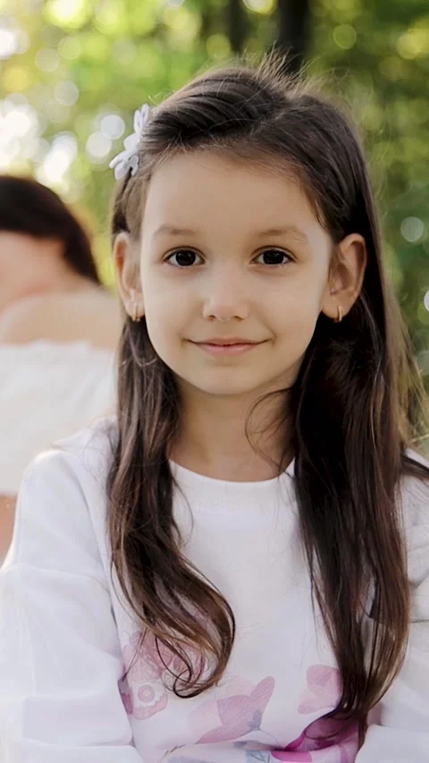 Cute affectionate adopted little child girl in foreground and foster mother Stock Footage 268747476