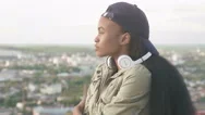 Cute African American Girl In Cap And Headphones Thoughtfully Looks Away Stock Footage