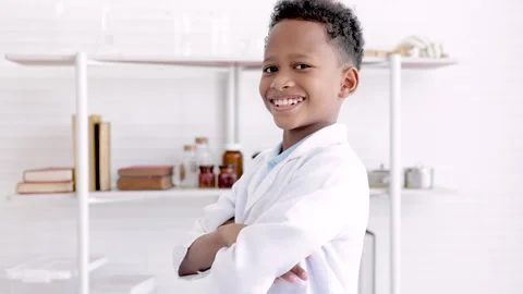 Cute African boy in laboratory coat looking at camera with smile, young sci.. Stock Footage 243660179