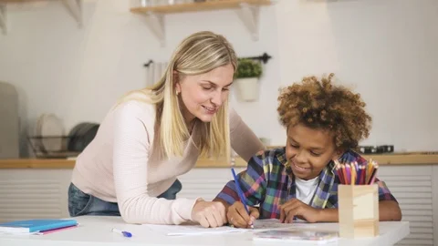 Cute american boy is finishing work sitting at the table in kitchen. Stock Footage 103672985