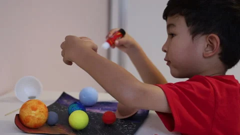 Cute asian boy making a 3D solar system on a list of paper. Stock Footage 165736455