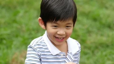 Cute asian child is blowing a soap bubbles outdoor,slow motion Stock Footage 76112295