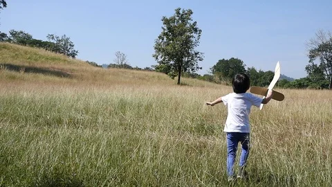 Cute Asian child playing pilot aviator in the field outdoors slow motion Stock Footage 85924949