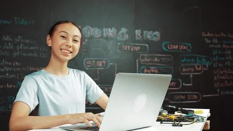 Cute asian girl programing system by using laptop at blackboard. Edification. Foto stock
