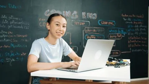 Cute asian girl programing system by using laptop at blackboard. Edification. Foto stock