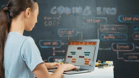 Cute asian girl programing system by using laptop at blackboard. Edification. 库存照片