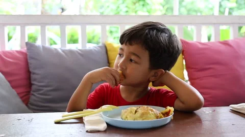 Cute asian preschool child eats lunch at nursery cafe. Stock Footage 159489952