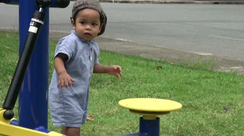 Cute Asian Toddler Explores Exercise Equipment At The Park 스톡 동영상 36814076