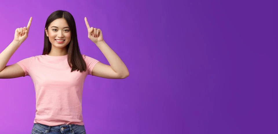 Cute assertive dark-haired asian woman wear pink t-shirt raise hands up, showing Stock Photos