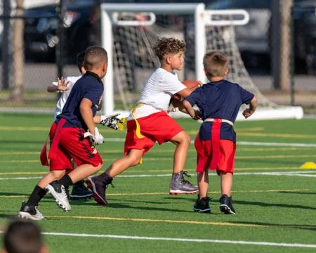Cute athletic boy playing flag football Stock Photos
