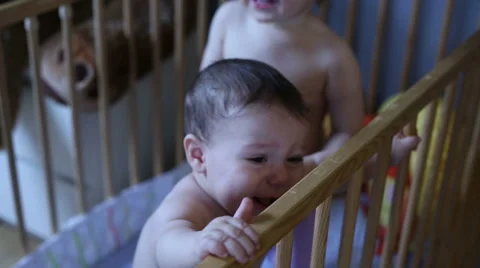 Cute babies boy are playing in crib, mood changes Stock Footage 62466804
