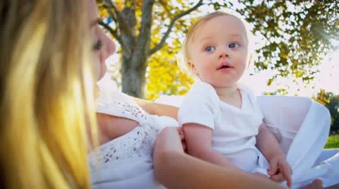 Cute Baby and Mom Sitting Outdoors Stock Footage