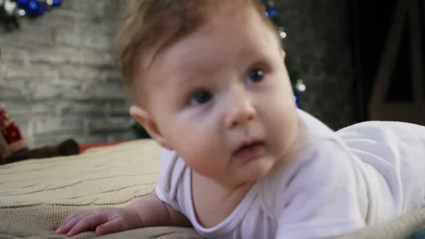 Cute baby boy lying on the bed and curiously looking into the camera and smiling Stock Footage 86519594