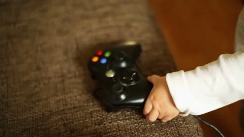 Cute, baby boy playing a computer game pad  Stock Footage 69938397
