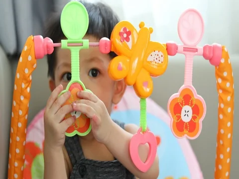 Cute baby boy using hand playing toy put in mouth Stock Footage 81261722