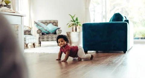 Cute baby crawling on floor Stock Photos