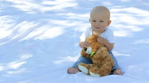 Cute baby denying and holding a bear toy Stock Footage