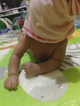 Cute Baby Drooling while Practicing Tummy Time on Colorful Mat Stock Photos