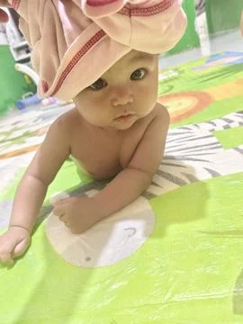 Cute Baby Drooling while Practicing Tummy Time on Colorful Mat Stock Photos