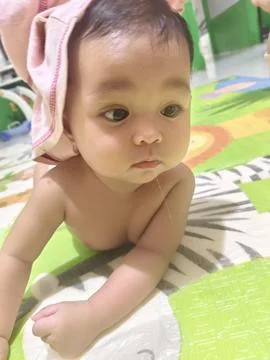 Cute Baby Drooling while Practicing Tummy Time on Colorful Mat Stock Photos