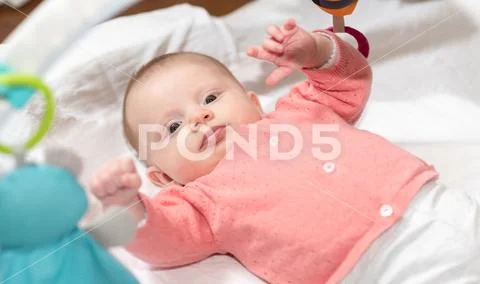 Cute baby girl playing with playmat toys Stock Photos
