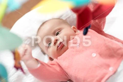 Cute baby girl playing with playmat toys Stock Photos