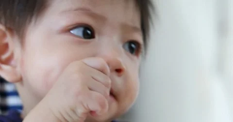 Cute baby kid using finger hand in mouth itchy gum Stock Footage 80469377