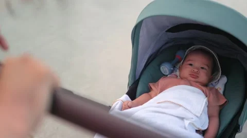 Cute Baby lies in a stroller while it is driving Stock Footage 201113890