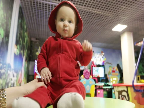 Cute baby sitting on a table and smiling at the children's center. Stock Footage 73378577