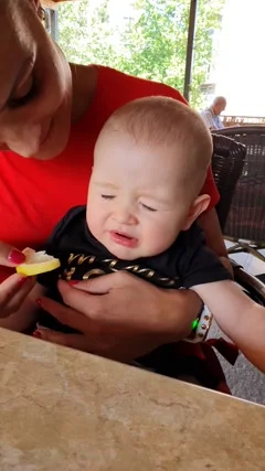 A cute baby tries eating lemon and makes... | Stock Video | Pond5