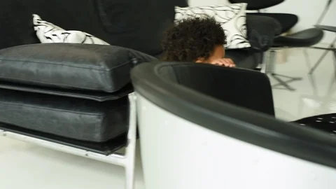 Cute black infant boy trying to climb onto chair. 库存影片 89035902