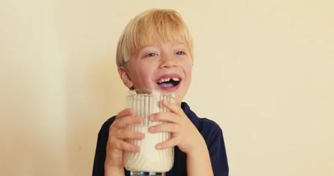 Cute blond boy drinking milk laughing Video stock 346983067