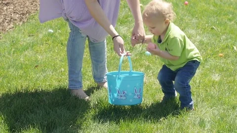 Cute Blond Boy Picks Up An Easter Egg And Shakes It Stock-Footage 77523946