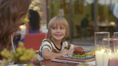 Cute Blond Boy Smiling Happily at Restaurant Dinner Table 4K 動画素材 344055342
