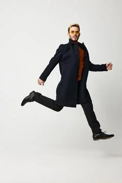 Cute blond guy running to the side in fashion clothes trend of the season pants Stock Photos