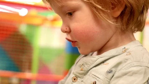 Cute blonde boy gesturing talking playing playroom children entertainment center 스톡 동영상 112703810