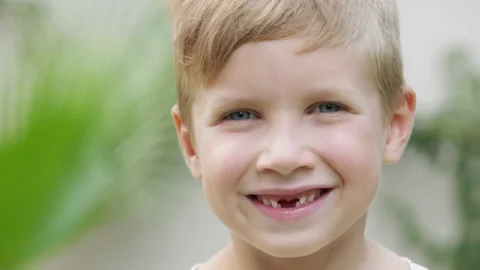 Cute blonde boy without front teeth smiling and looking at camera Stock Footage 205275909
