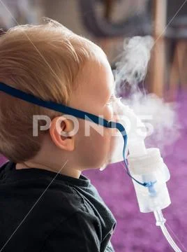 Cute blonde kid inhaling at home Stock Photos