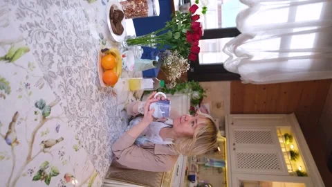Cute blonde in the kitchen, drinking morning coffee. She holds a mug with a hot Stock Footage 283932157